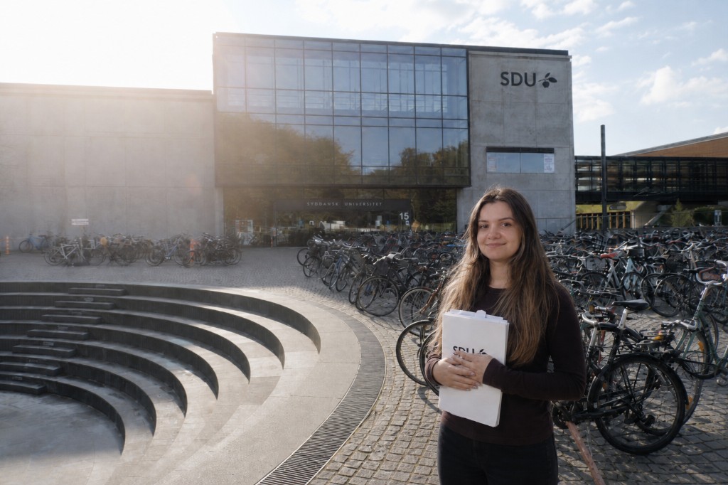 Octavia Sirbu at Syddansk Universitet graduation, holding an SDU folder
